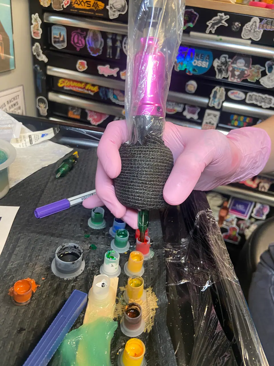 Una máquina de tatuaje rotativa se carga con tinta antes de empezar un procedimiento