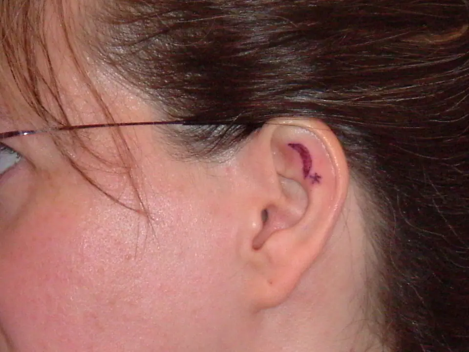 Tatuaje pequeño de luna y estrella en el pabellón de la oreja