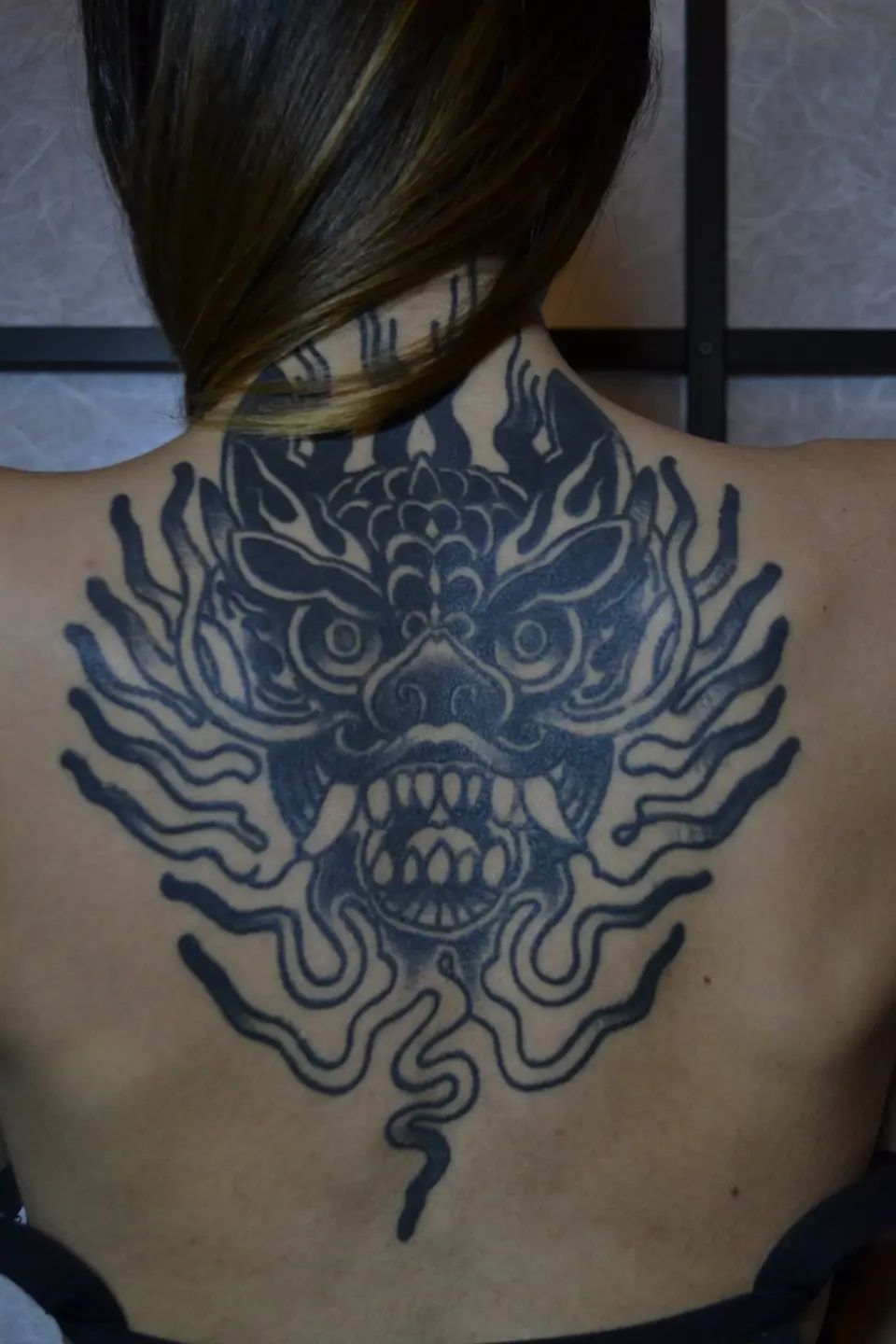 Tatuaje blackwork de dragón en la espalda
